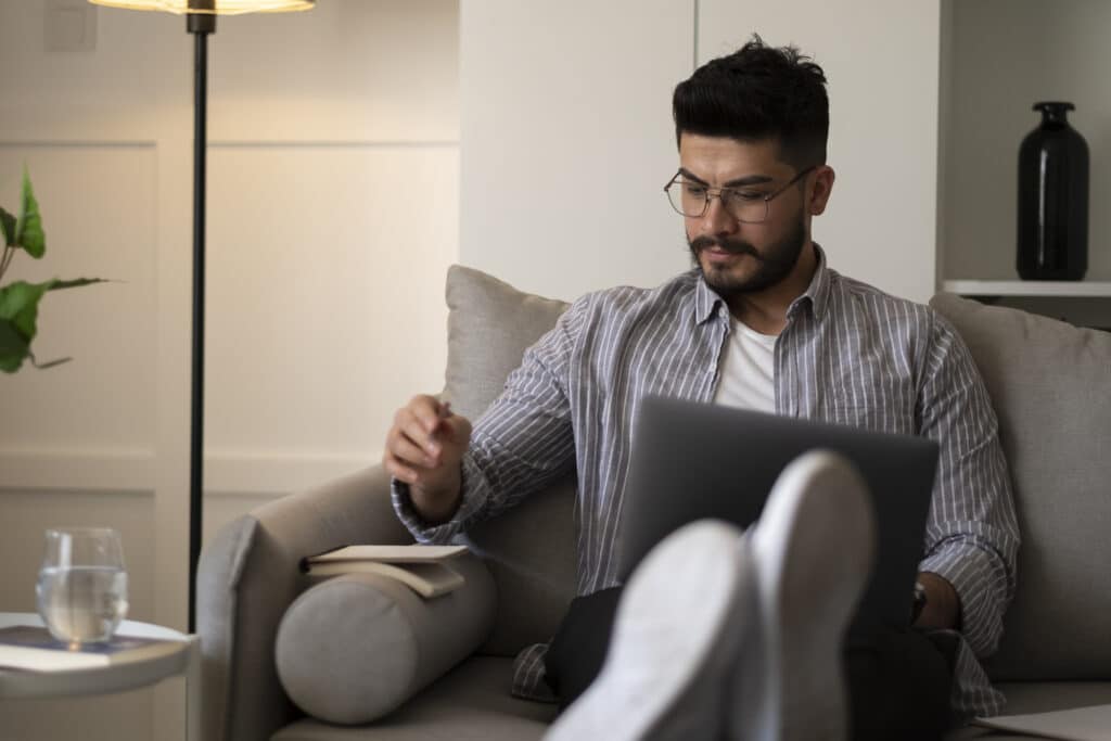 Happy young caucasian man working on computer.