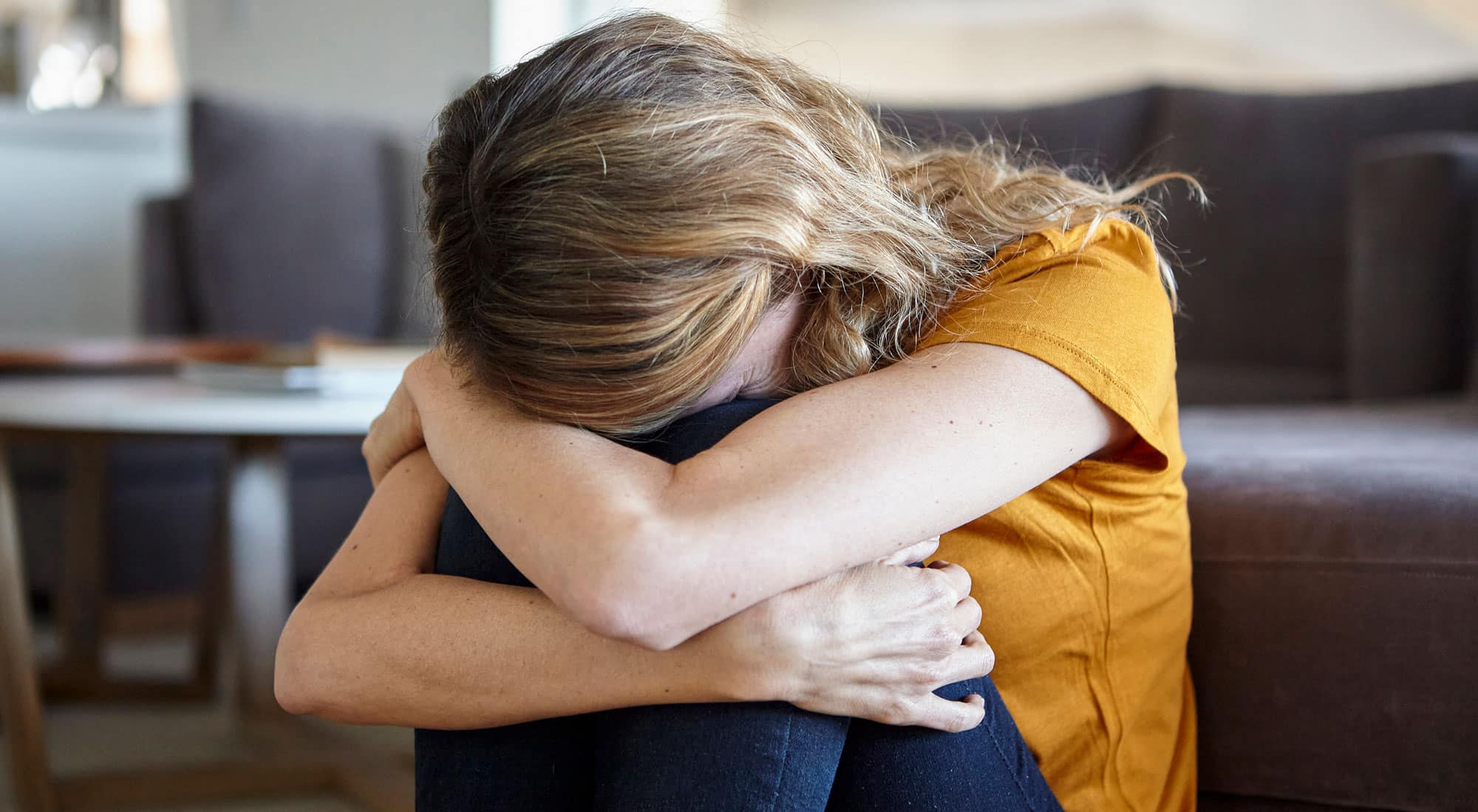 woman upset curled up in ball