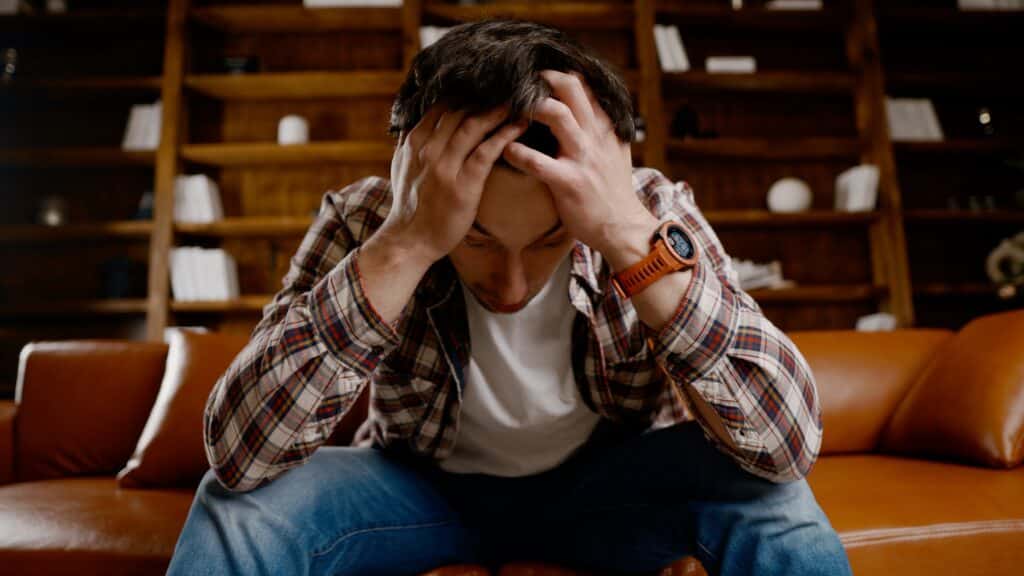 Alcohol addiction at young age. Caucasian male cannot stop drinking alcohol, drunken lonely male drinks wine from bottle. Loneliness, depression and alcoholism during Christmas and New Year holidays.